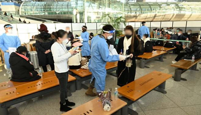 2일 인천국제공항 제1여객터미널을 통해 입국한 중국발 입국자들이 PCR 검사를 받은 후 공항교통센터에 마련된 대기장소에서 결과를 기다리고 있다. [사진=뉴스1]