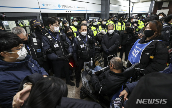 전국장애인차별철폐연대(전장연) 회원들이 지난 2일 오전 서울 지하철 4호선 삼각지역에서  장애인 권리 예산 보장을 촉구하는 출근길 지하철 탑승 시위에서 탑승을 시도하고 있다. 전장연은 법원 조정안에 맞춰 5분 내 탑승을 수용하겠다고 밝혔다. [사진=뉴시스]