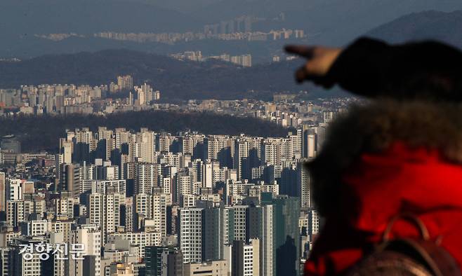 국토교통부가 부동산 규제 완화를 주요 내용으로 윤석열 대통령에게 올해 업무계획을 보고한 3일 서울 남산에서 한 시민이 밀집된 아파트를 내려다보고 있다. 성동훈 기자