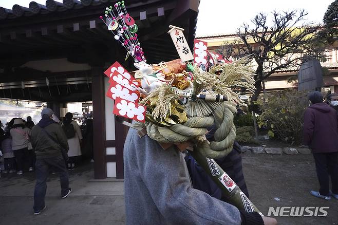 [도쿄=AP/뉴시스] 2일 일본 도쿄 근처 가와사키에 있는 다이시 사찰에서 방문객이 '쿠마데(갈퀴)' 모양의 행운 부적을 들고 다니고 있다. 많은 방문객들은 '하츠모데'에 신사나 사원을 새해 첫날 방문해 행운을 기원한다. 2023.01.04.