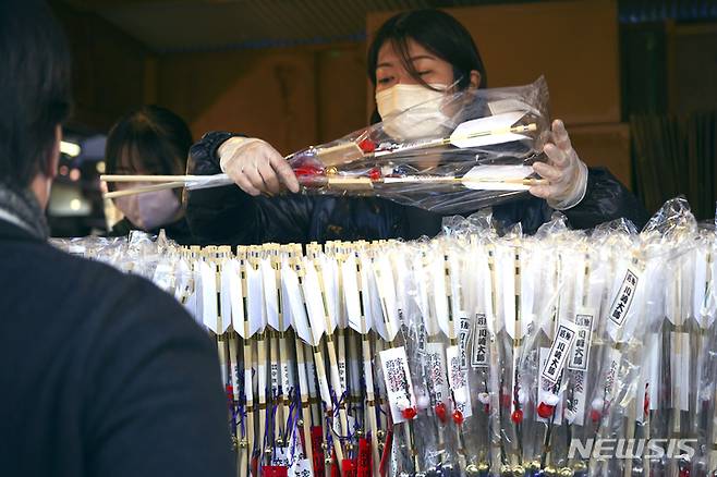 [도쿄=AP/뉴시스] 2일 일본 도쿄 근처 가와사키에 있는 다이시 사찰 기념품점에서 새해 첫 신사나 사찰을 방문해 행운을 기원하는 '하츠모데' 방문객들에게  직원이 액운을 쫓아내기 위한 '하마야' 또는 의식용 화살을 판매하고 있다. 2023.01.04.<font _mstmutation="1" _msthash="178997" _msttexthash="372645468"></font>