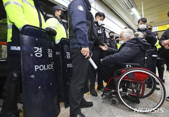 [서울=뉴시스] 최진석 기자 = 박경석 전국장애인차별철폐연대(전장연) 상임공동대표가 지난 3일 서울 용산구 삼각지역에서 지하철에 탑승하려다 지하철보안관들에게 막히고 있다. 2023.01.03. myjs@newsis.com