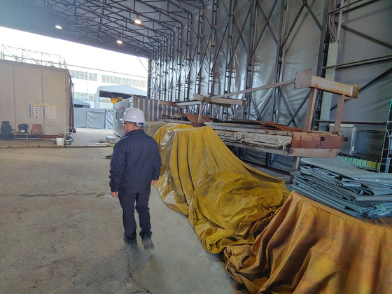 Gilsan Engineering’s CEO Kim Yong-yi looks over the heat treatment equipment which is being stored at the factory’s garage on Jan. 2. [JEONG JONG-HOON]