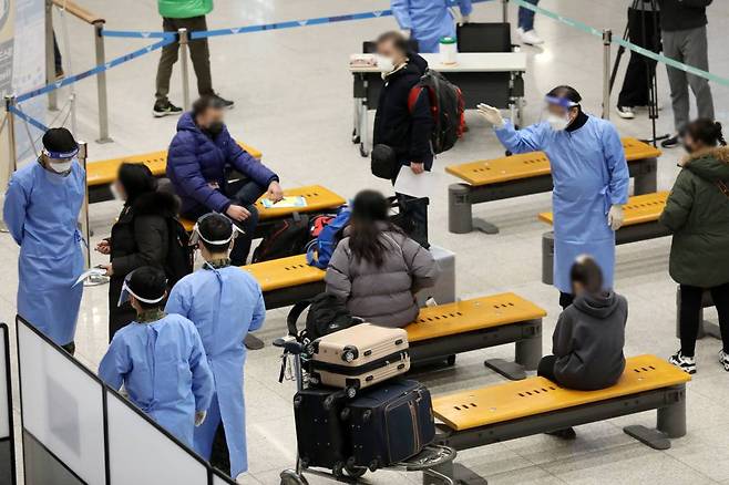 [인천공항=뉴시스] 조성우 기자 = 중국에서 국내로 들어오는 입국자들의 코로나19 음성 확인서 제출이 의무화된 5일 오후 인천국제공항 제1여객터미널에서 중국발 입국자들이 PCR 검사대기 장소에 앉아 있다. 2023.01.05.