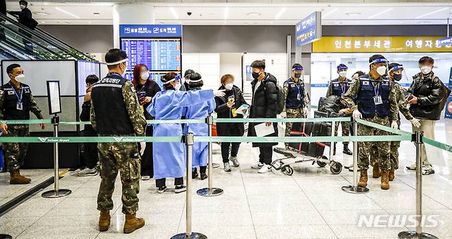 [인천공항=뉴시스] 정병혁 기자 =  중국발 입국자 코로나19 검사 의무화가 시행중인 6일 오후 인천국제공항 제2여객터미널에서 선양발 입국자들이 검역 지원 육군 장병들과 PCR검사 대기장소로 이동하고 있다. 2023.01.06. jhope@newsis.com