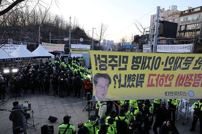 2022년 12월30일 서울 용산구 녹사평역 시민분향소에서 ‘이태원 참사 시민추모제’가 진행되는 한쪽에 보수단체가 내건 펼침막이 보인다. 류우종 기자