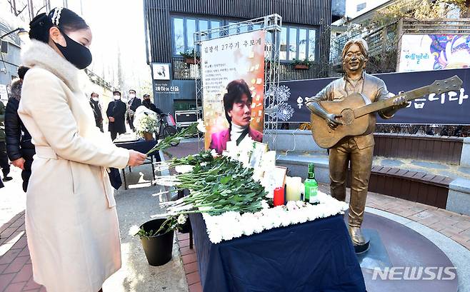 [대구=뉴시스] 이무열 기자 = ‘영원한 가객' 故 김광석 27주기 추모식이 열린 6일 오후 대구 중구 김광석 다시그리기길에서 참석자가 헌화하고 있다. 2023.01.06. lmy@newsis.com