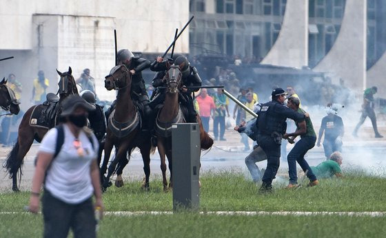 대통령궁에 난입한 시위대가 말을 탄 경찰을 공격하고 있다. AFP=연합뉴스