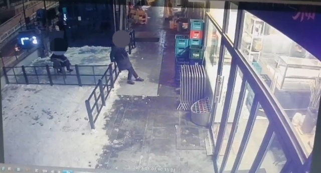 가게 앞 테라스를 지나던 일행이 눈 위에서 스케이트를 타듯 미끄러지며 장난을 치고 있다. A씨가 공개한  CCTV 영상 캡처본. A씨 제공