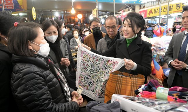 김건희 여사가 11일 대구 서문시장을 양말가게를 찾아 상인으로부터 선물을 받고 있다. 2023.01.11  대통령실사진기자단