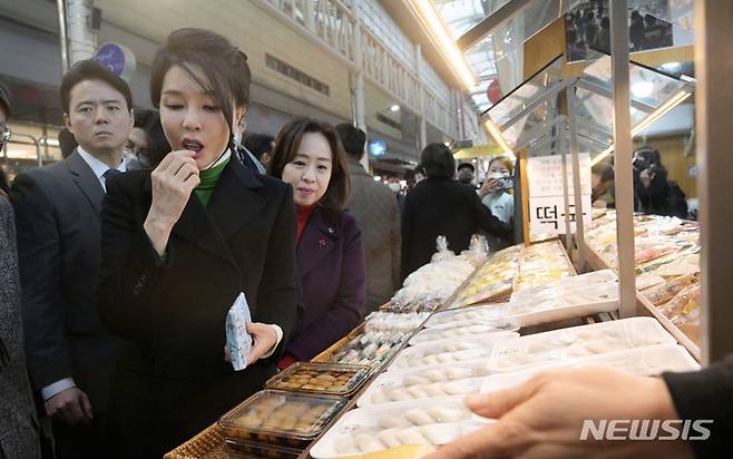 [대구=뉴시스] 홍효식 기자 = 윤석열 대통령 부인 김건희 여사가 11일 대구 서문시장을 찾아 떡을 시식하고 있다. (대통령실통신사진기자단) 2023.01.11. yesphoto@newsis.com
