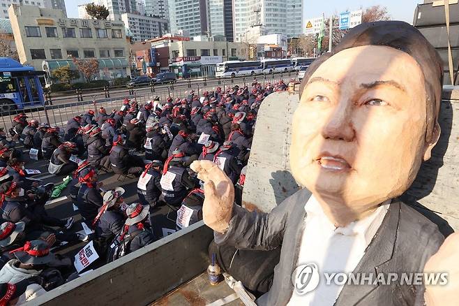 건설노조 결의대회에 등장한 윤석열 대통령 모형 (서울=연합뉴스) 신현우 기자 = 전국건설노동조합 조합원들이 11일 오후 서울 지하철 4호선 삼각지역 인근에서 결의대회를 열고 윤석열 정부 규탄하고 있다. 2023.1.11 nowwego@yna.co.kr