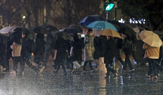 겨울비가 내린 지난달 12일 서울 종로구 세종대로사거리에서 시민들이 우산을 쓰고 이동하고 있다. 사진=뉴시스