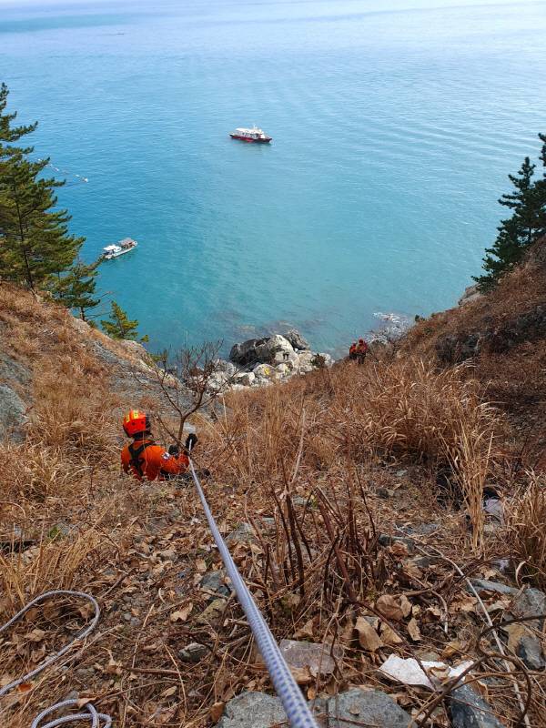 12일 경남 거제시 남부면 여차전망대에서 승용차가 200ｍ 절벽 아래로 추락한 현장을 119 대원이 확인하고 있다. 경남소방본부 제공