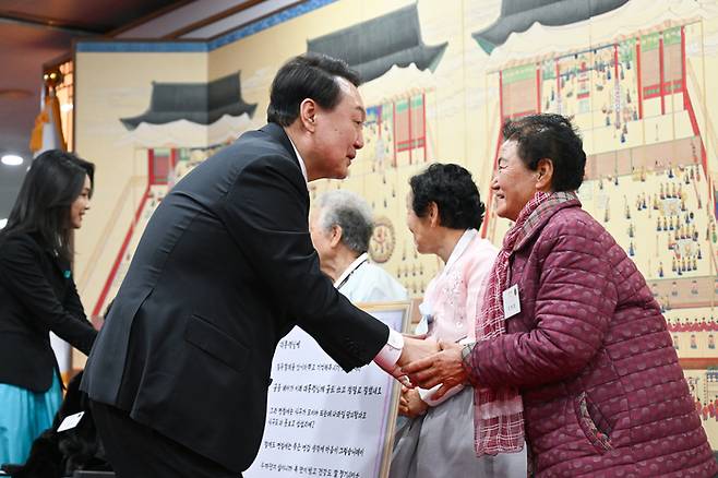 윤석열 대통령과 김건희 여사가 12일 오후 서울 용산 대통령실 청사에서 ‘칠곡할매글꼴’의 주인공인 칠곡 할머니들과 만나 인사를 나누고 있다. [사진출처=연합뉴스]