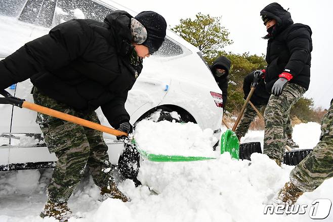 해병대 제9여단 장병들이 24일 오후 제주 서귀포시 안덕면 광평리 산록도로 일원에서 제설 대민지원에 나서 폭설에 고립된 차량 5대를 구조하고 통행로 확보를 위한 제설작업을 실시했다.(해병대 제9여단 제공)2022.12.24/뉴스1 ⓒ News1 강승남 기자