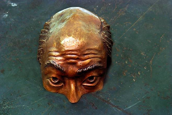 <눈칫밥 삼십 년1>, 1999. 하루하루 살얼음판이던 아이엠에프 시기 샐러리맨들의 일상은 하루하루 총알이 빗발치는 전쟁터 같았다. 근무지에서 곧 사라질 자기 차례를 숨죽이며 잠시라도 피해보려 애쓰는 모습을 맨홀 뚜껑 아래에서 머리만 내놓고 눈치를 보고 있는 형상으로 긴장감 있게 표현하였다. 구본주기념사업회 제공