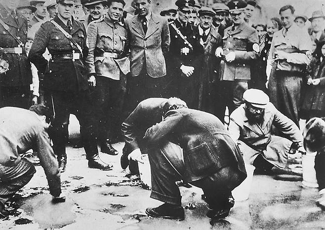 1938년 4월 오스트리아 빈에서 유대인들이 시민들에 의해 도로를 닦는 청소를 강요당하고 있다.  할례를 받은 성기를 가진 유대인 남성들은 쉽게 나치의 표적이 됐다.