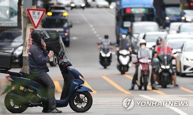 (서울=연합뉴스) 김도훈 기자 = 서울 시내의 한 교차로를 통과하는 오토바이 모습들. 2022.6.28