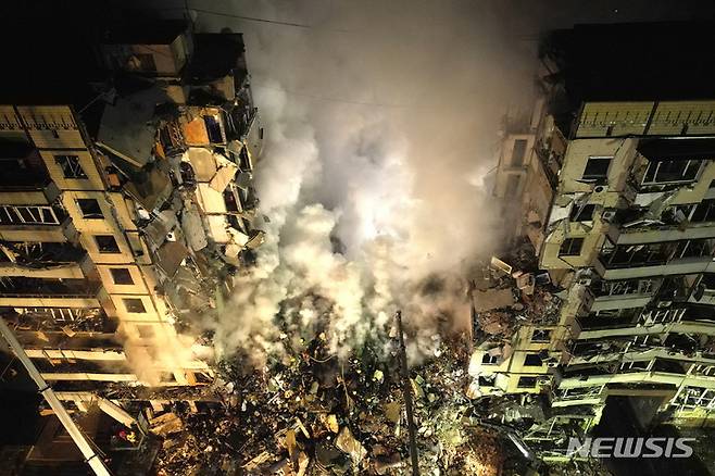 [AP/뉴시스] 14일 러시아군의 미사일 및 로켓 공격을 받은 드니프로시 아파트 파괴 현장에 구조대가 급파되었다