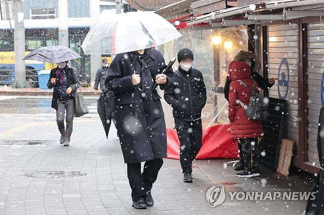 눈 내리는 서울 (서울=연합뉴스) 서대연 기자 = 눈이 내린 15일 오전 시민들이 서울 동대문구 청량리역 인근에서 우산을 쓰거나 모자를 쓰고 걷고 있다. 2023.1.15 dwise@yna.co.kr