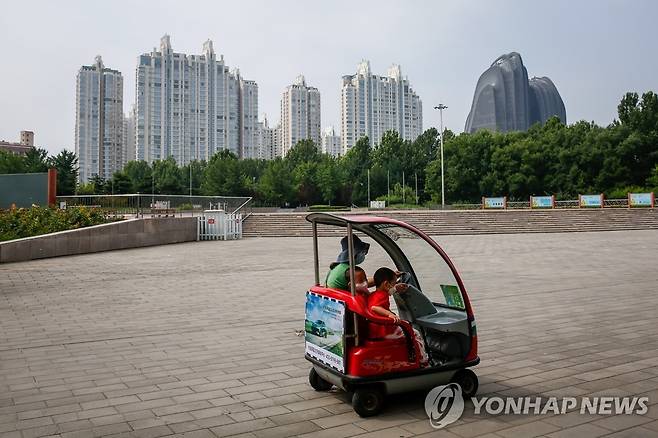 중국 '인구 절벽' 위기 (베이징 EPA=연합뉴스) 지난해 8월 중국 베이징 시내의 한 공원에서 한 여성이 자녀들과 함께 전기차를 타고 있는 모습. 중국 정부는 '인구 절벽' 위기를 극복하기 위한 다양한 대책을 내놓았지만 지난해 중국 인구는 61년만에 처음으로 감소세를 보였다.  2023.1.17 [재판매 및 DB 금지]