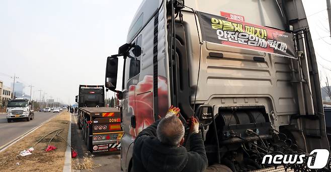 9일 민주노총 공공운수노조 화물연대의 파업철회 찬반투표 결과 파업종료로 가결 되면서 충남 당진시 현대글로비스 앞에서 파업 농성을 하던 화물연대 조합원이 화물차량에 부착한 '일몰제 폐지!, 안전운임제 확대' 플래카드를 철거하고 있다. 2022.12.9/뉴스1 ⓒ News1 김기남 기자