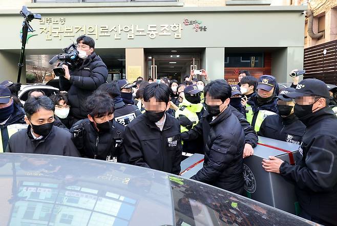 18일 오후 서울 영등포구 민주노총 전국보건의료산업노동조합 사무실에서 국가보안법 위반 혐의 관련 압수수색을 마친 국정원 직원들이 압수품을 옮기고 있다./연합뉴스