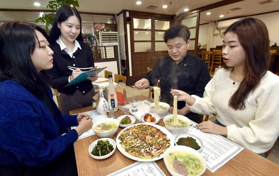 서울 양천구 ‘한옥안동국시’ 사장이 골목경제 부활 프로젝트에 참여한 숙명여대 ‘같이가게’ 팀원들과 빅데이터 상권분석 결과 등을 논의하고 있다. KT 제공