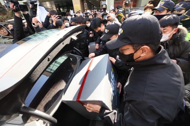 18일 오후 서울 영등포구 민주노총 전국보건의료산업노동조합 사무실에서 국가보안법 위반 혐의 관련 압수수색을 마친 국정원 직원들이 압수품을 옮기고 있다. 연합뉴스