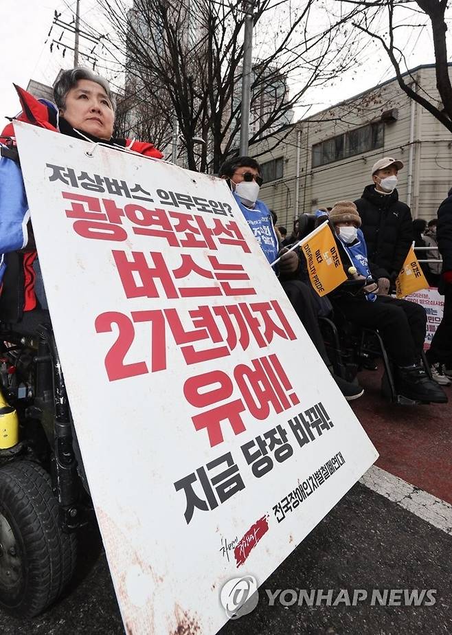 전국장애인차별철폐연대(전장연) 회원이 19일 오후 서울 서초구 남부터미널 앞에서 열린 시외버스 이동권 촉구 집회에서 팻말을 들고 있다 <자료=연합뉴스>