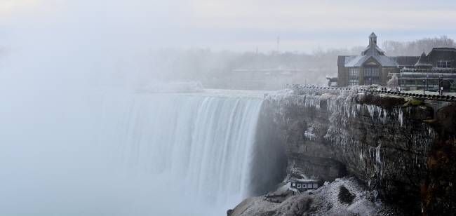 겨울철의 나이아가라 폭포 모습. 거센 폭포의 물줄기가 피워올린 물안개가 벼랑 곳곳에 얼어붙었다. 절벽 아래 작은 건물이 엘리베이터를 타고 폭포 뒤쪽으로 내려가는 ‘저니 비하인드 더 폴스’ 체험 프로그램의 전망 덱이다. 여기서 보는 폭포의 위용이 압도적인데 겨울철에는 안전문제로 전망 덱의 옥외공간 출입을 금지한다.