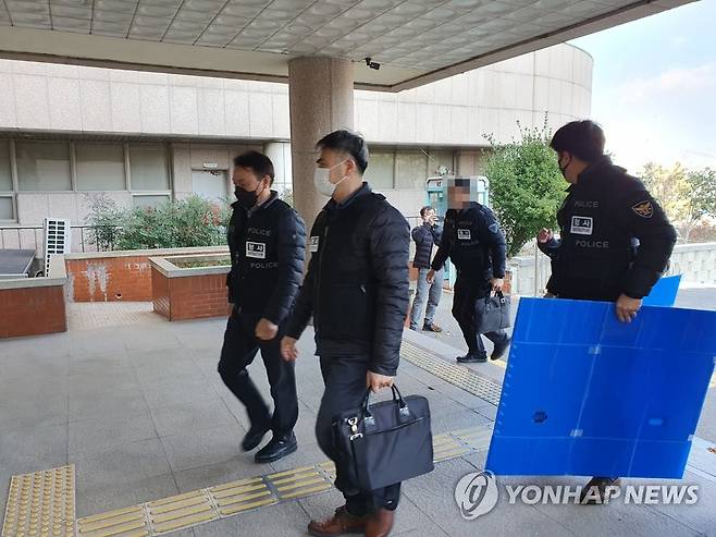 화물연대 압수 수색을 하는 경찰 (포항=연합뉴스) 경북경찰청이 7일 오후 민주노총 공공운수노조 화물연대본부 포항지역본부 사무실을 압수수색 하고 있다. 화물연대 관계자는 운송사 업체 관계자들에게 "파업에 동참하지 않으면 응징하겠다"는 내용의 문자메시지를 보낸 혐의(특수협박)를 받고 있다. 2022.12.7 [경북경찰청 제공, 재판매 및 DB 금지] sunhyung@yna.co.kr