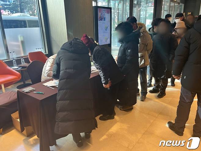 강남구에서 마련한 임시거주 호텔에 도착해 입실카드를 받기 위해 대기 중인 구룡마을 이재민들. 이들 역시 넋이 나간 표정이었다. 2023.01.20./뉴스1 ⓒNews1 원태성 기자