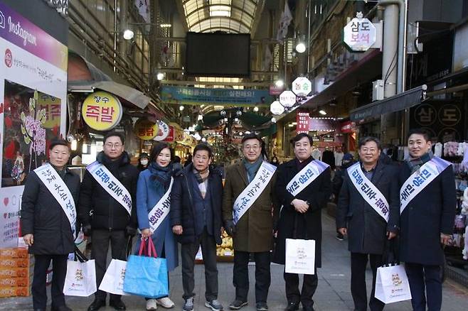 설 연휴를 앞두고 구리전통시장을 찾은 윤호중 의원(가운데)와 구리시의회 의원 및 민주당 당원.ⓒ윤호중 의원실