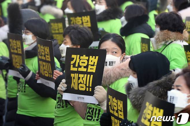 (서울=뉴스1) 황기선 기자 = 대한간호협회 회원들이 4일 오전 서울 영등포구 여의도 국민의힘 당사 앞에서 손팻말을 들고 국회에 233일째 계류 중인 간호법 제정을 촉구하고 있다. 2023.1.4/뉴스1  Copyright (C) 뉴스1. All rights reserved. 무단 전재 및 재배포 금지.