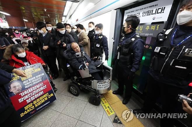 전장연 시위 (서울=연합뉴스) 신준희 기자 = 20일 지하철 4호선 서울역 승강장에서 전국장애인차별철폐연대 회원들이 '오이도역 리프트 추락 참사 22주기 집회'를 마치고 열차에 탑승하려다 막히고 있다. 2023.1.20 hama@yna.co.kr