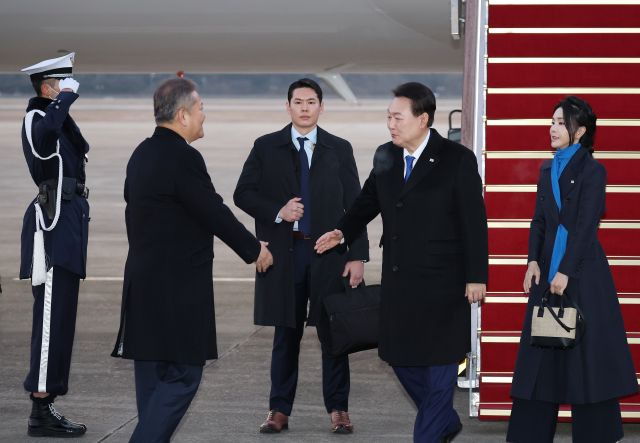 윤석열 대통령이 21일 오전 경기도 성남 서울공항으로 귀국해 이상민 행정안전부 장관과 악수하고 있다. 연합뉴스