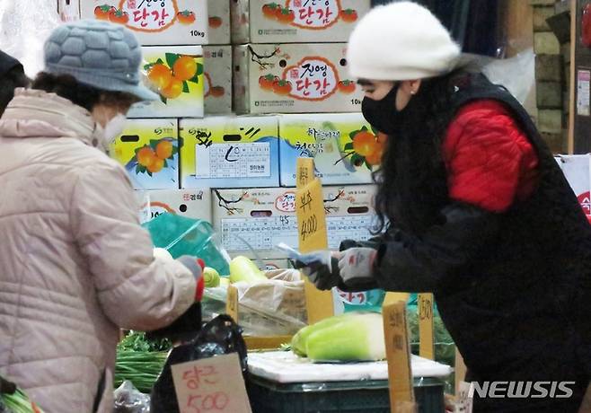 [인천=뉴시스] 김동영 기자 = 2023년 계묘년 설을 이틀 앞둔 20일 오후 인천 남동구 모래내시장에서 상인이 손님을 맞이하고 있다. 2023.01.20. dy0121@newsis.com