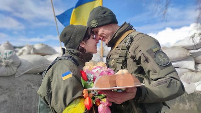 지난해 3월 8일 우크라이나 방위군 대원인 올렉산드르(오른쪽)와 올레나가 결혼식서 얼굴을 맞대고 있다. 우크라이나=로이터 연합뉴스