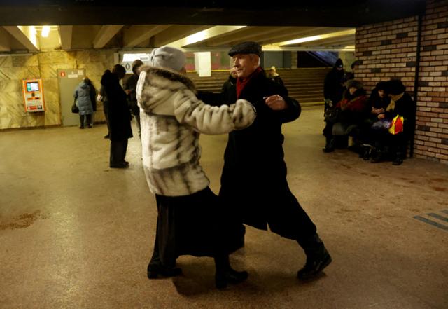 14일 우크라이나 키이우에서 대규모 러시아 미사일 공격을 피해 지하철역 내부로 대피한 시민들이 음악에 맞춰 춤을 추고 있다. 키이우=로이터 연합뉴스