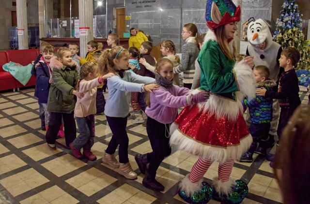 지난해 12월 17일 우크라이나 하르키우에서 어린이들이 정교회 성 니콜라스의 날 축하하며 기차놀이를 하고 있다. 하르키우=EPA 연합뉴스
