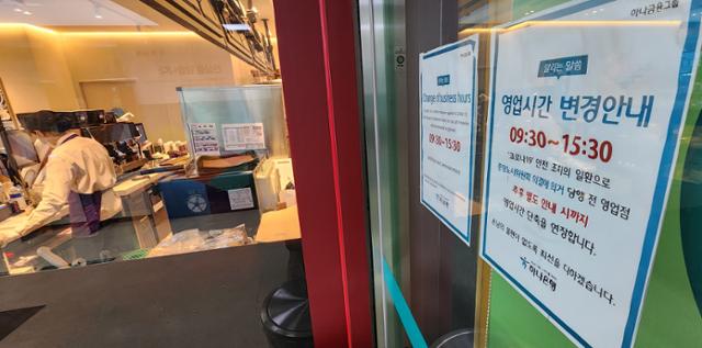 24일 서울 시내 한 은행 자동화기기 점포에 코로나19 안전조치에 따른 영업시간 조정 안내문이 붙어 있다. 연합뉴스