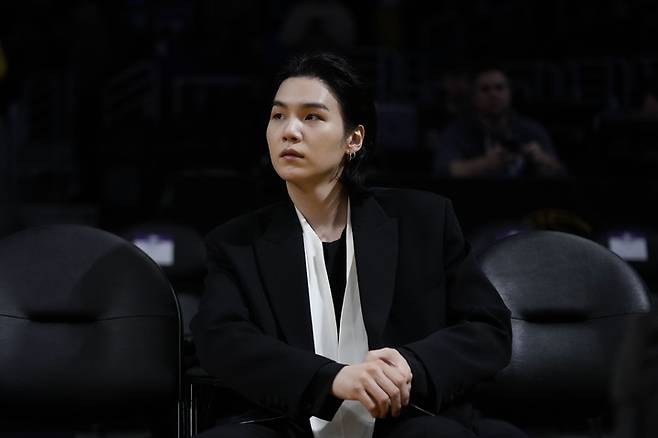 [서울=AP/뉴시스] 발렌티노 입은 방탄소년단 슈가. 12일(이하 현지시간) 오후 미국 캘리포니아 주(州) 로스앤젤레스(LA) 크립토닷컴 아레나에서 열린 미국 프로농구(NBA) LA레이커스 대 댈러스 매버릭스의 경기를 관람하는 모습.