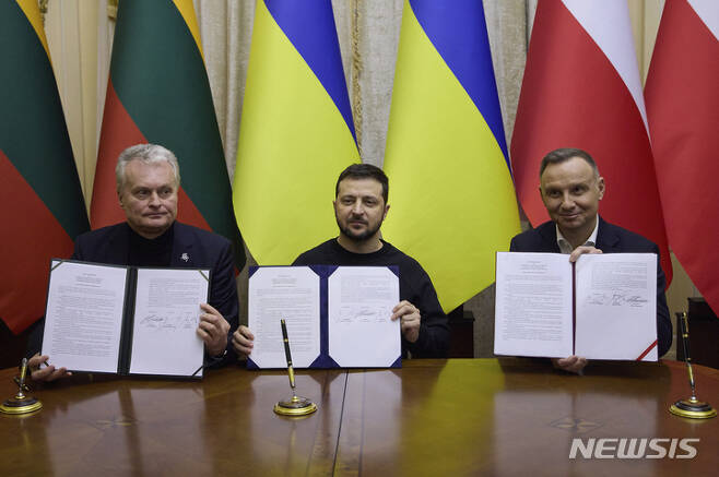[르비우=AP/뉴시스] 볼로디미르 젤렌스키(가운데) 우크라이나 대통령이 11일(현지시간) 르비우에서 기타나스 나우세다(왼쪽) 리투아니아 대통령, 안제이 두다 폴란드 대통령과 회담 후 서명한 협정서를 들고 기념 촬영하고 있다. 두다 대통령은 이날 우크라이나에 독일 주력 전차인 레오파드 전차를 지원하겠다고 밝혔다. 2023.01.12.