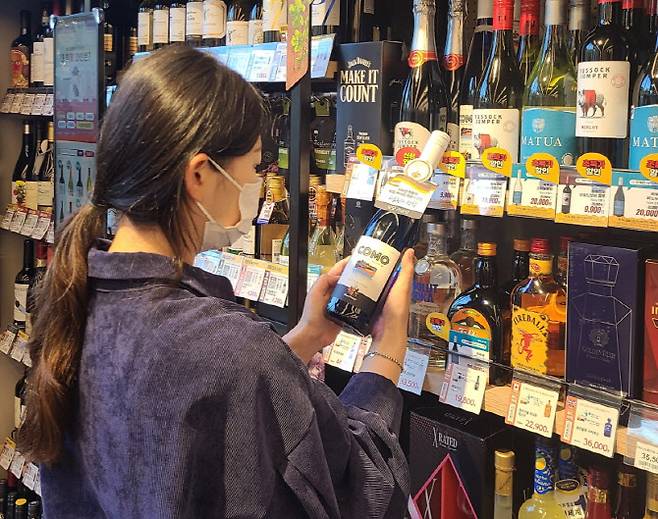 고객이 이마트24 매장에서 와인 상품을 살펴보고 있는 모습(사진=이마트24)