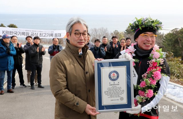 조웅래 회장(오른쪽)이 26일 강원도 고성 통일전망대로 들어와 대한민국 한바퀴 5228km를 완주한 뒤 김덕은 한국기록원 원장으로부터 ‘대한민국 한바퀴 국내 최단시간 완주’ 증서를 받고 있다. 고성=이훈구 기자 ufo@donga.com