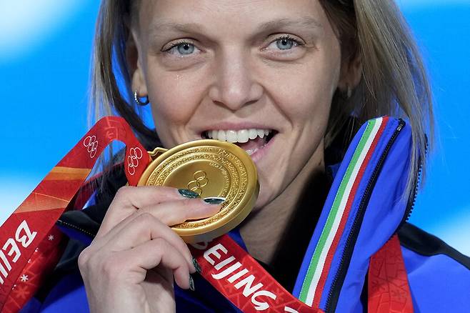 이탈리아 아리안나 폰타나가 지난해 2월 2022 베이징겨울올림픽 메달 세리머니에서 쇼트트랙 여자 500m 금메달을 입에 무는 포즈를 취하고 있다. 베이징/AP 연합뉴스
