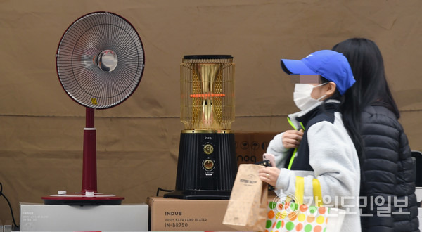 춘천 명동거리에서 시민들이 온열기기 매대 앞을 지나고 있다. 