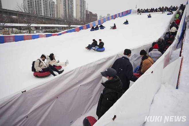 대설주의보가 발효된 26일 오후 서울 광진구 뚝섬한강공원 눈썰매장에서 시민들이 눈썰매를 즐기고 있다.